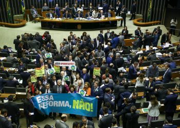 No plenário da Câmara, deputados da oposição erguem faixas e cartazes contra a reforma da Previdência (Foto: Pedro Ladeira/Folhapress)