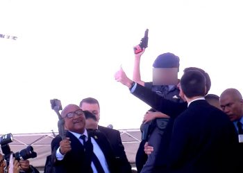 Criança no colo de Bolsonaro aponta arma de brinquedo para o alto durante evento de formação de sargentos da Polícia Militar de São Paulo (Foto: Reprodução/TV Globo)