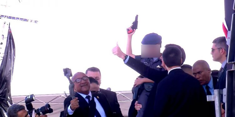 Criança com farda da PM e arma de brinquedo na mão posa para fotos com Bolsonaro