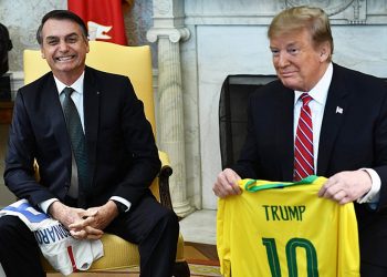 O presidente dos Estados Unidos Donald Trump recebe uma camisa da seleção brasileira de Jair Bolsonaro  em março de 2019 (Foto: Brendan Smialowski/AFP)