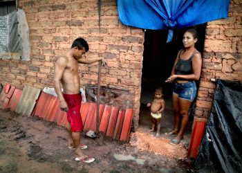 Sem dinheiro, o casal Denilson Araujo dos Santos, 22, e Ivanete Ribeiro dos Santos,19, teve que trocar o gás de cozinha pela lenha na hora de cozinhar feijão e mandioca para a filha (Foto: Junior Foicinha/Folhapress/FRILA)