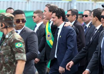 O presidente Jair Bolsonaro (PSL) desfila abraçado a Sergio Moro para cumprimentar o público no desfile de 7 de setembro, na Esplanada dos Ministérios (Foto: Pedro Ladeira/Folhapress)