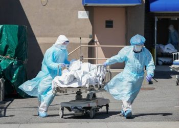 Cadáver de morto por coronavírus deixa hospital (Foto: Bryan R. Smith/AFP)