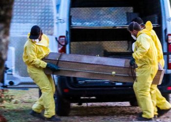 Homens carregam corpo de paciente morta por covid-19 (novo coronavírus) no Cemitério Santo Antônio em Sorocaba (SP) (Foto: Cadu Rolim/Fotoarena/Estadão Conteúdo)