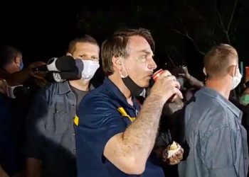 Jair Bolsonaro come cachorro-quente em Brasília (Foto: Reprodução)