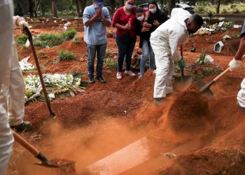 Parentes assistem a coveiros vestindo roupas de proteção enterrando o caixão de um homem que morreu da doença por coronavírus (Covid-19), no cemitério de Vila Formosa, em São Paulo (Foto: Amanda PerobelliI/Reuters)