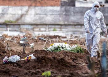 Agente funerário caminha em cemitério do Rio de Janeiro durante pandemia do coronavírus (Foto: Buda Mendes/Getty Images)