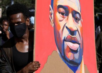 Manifestante segura cartaz com rosto de George Floyd durante protesto em Nova York (Foto: Caitlin Ochs/Reuters)