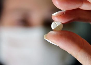 Agente de saúde segura comprimido de cloroquina em hospital de Porto Alegre (Foto: Diego Vara)