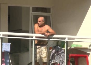 Queiroz pega sol na sacada do apartamento onde cumpre prisão domiciliar, no Rio (Foto: Reprodução/Agência O Globo)