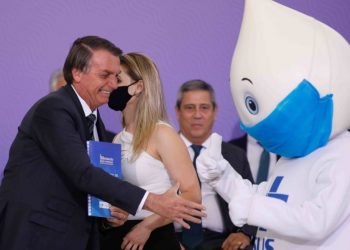 Bolsonaro estende a mão ao Zé Gotinha, personagem símbolo do programa de vacinação brasileiro, em evento no Planalto (Foto: Sérgio Lima/Poder360)