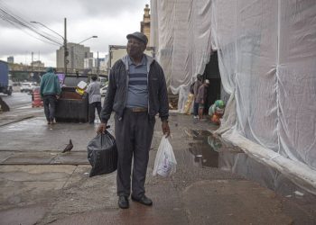 Vagner Benedito, 67, mostra alimentos que pegou pouco antes do descarte (Foto: Danilo Verpa/Folhapress)