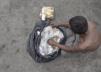 Homem separa alimentos que iriam para o lixo no Mercadão Municipal em São Paulo (Foto: Danilo Verpa/Folhapress)