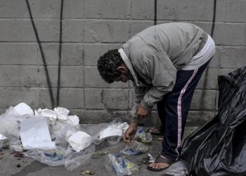 Morador procura resto de comida no lixo em São Paulo (Foto: Reinaldo Canato/UOL)