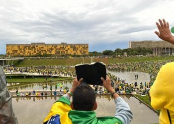 Homem reza por intervenção militar à frente do Congresso durante invasão (Foto: Lucas Borges Teixeira/UOL)