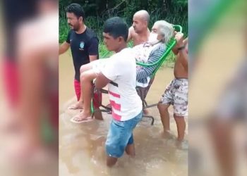 Idosa é levada para casa sobre cadeira por conta de área inundada em Juazeiro do Norte (Foto: Reprodução)